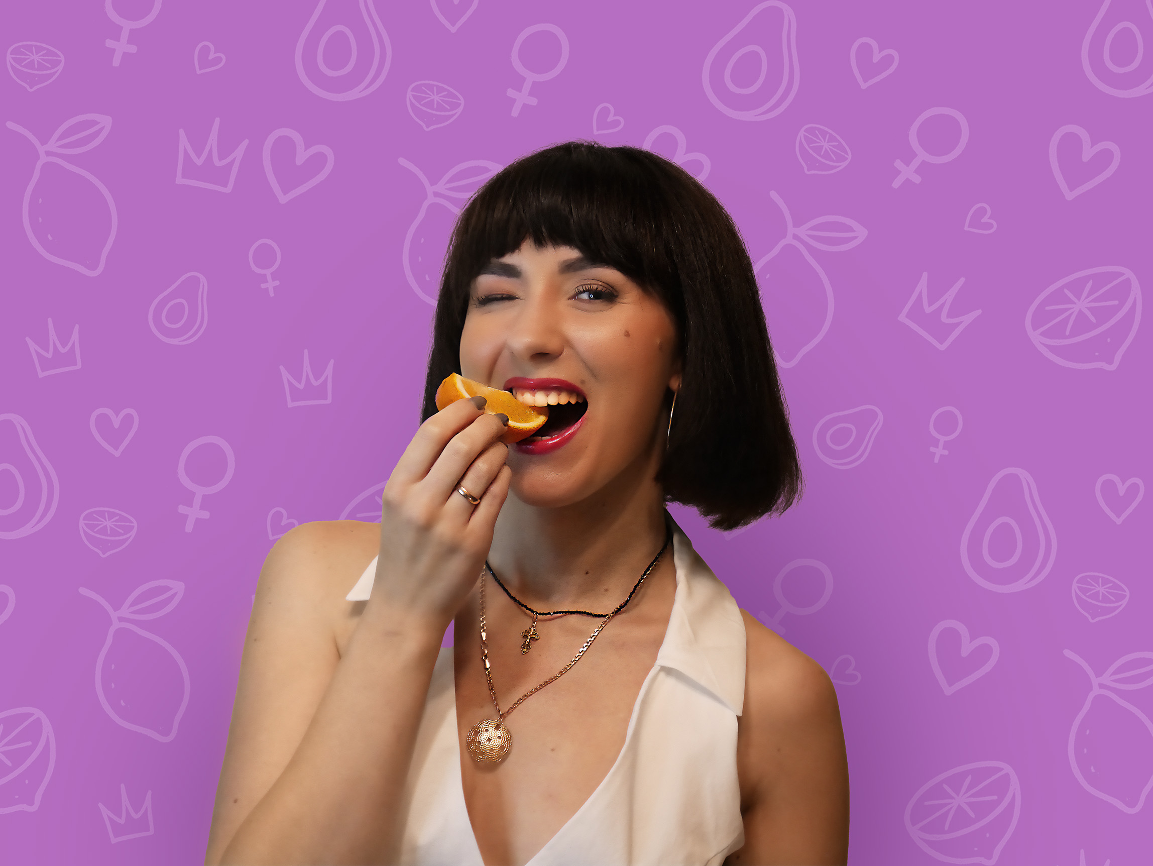 Certified personal nutritionist enjoying a fresh orange in a bright kitchen, promoting healthy eating and balanced nutrition.